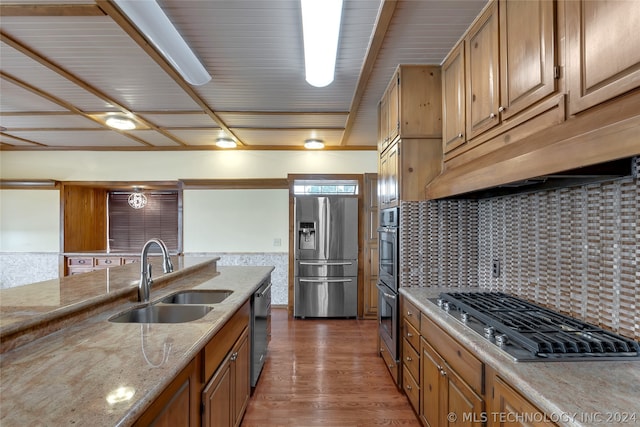 kitchen featuring light stone countertops, sink, dark hardwood / wood-style floors, decorative backsplash, and appliances with stainless steel finishes