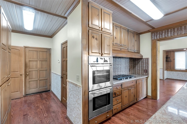 kitchen with appliances with stainless steel finishes, dark hardwood / wood-style floors, crown molding, and wooden ceiling