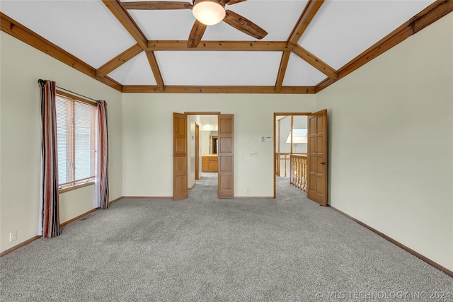 carpeted spare room featuring vaulted ceiling with beams and ceiling fan