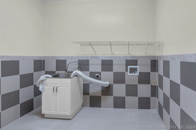 bathroom with tile patterned flooring, tile walls, and sink