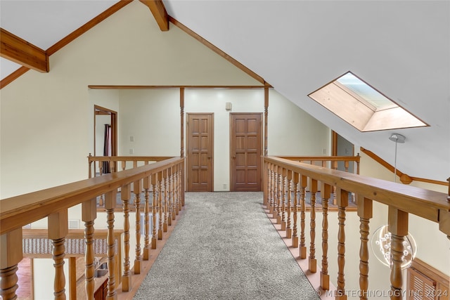 corridor featuring a skylight, light carpet, beamed ceiling, and high vaulted ceiling