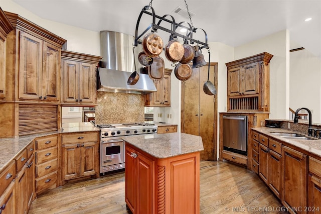 kitchen featuring a center island, range hood, appliances with stainless steel finishes, and light hardwood / wood-style flooring