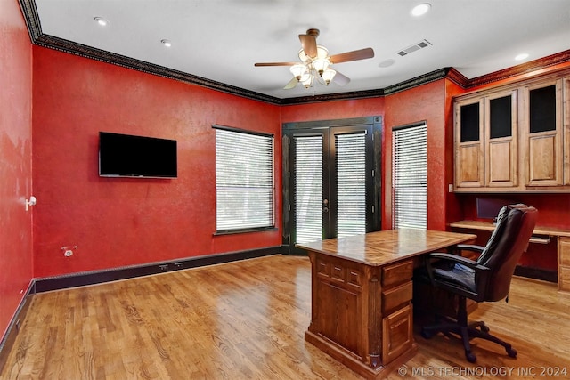 unfurnished office with french doors, crown molding, ceiling fan, built in desk, and light wood-type flooring