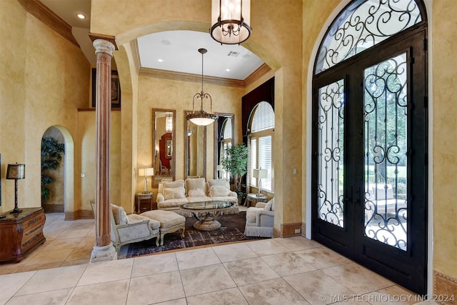 tiled foyer with french doors, crown molding, and a high ceiling