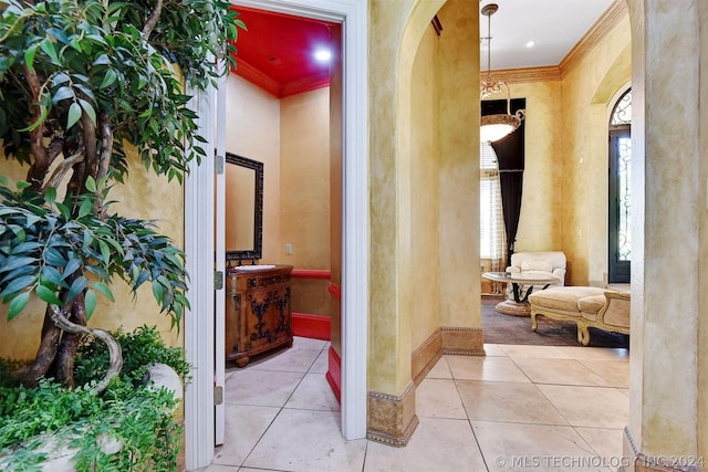 corridor with light tile patterned flooring and ornamental molding