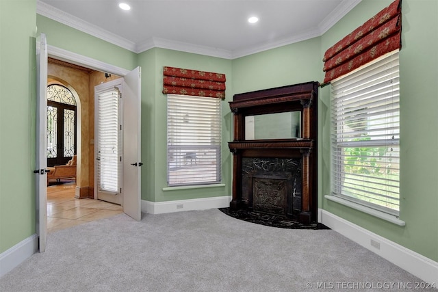 unfurnished living room with crown molding, light carpet, and french doors