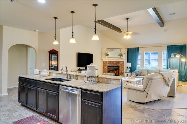 kitchen with stainless steel dishwasher, sink, beamed ceiling, hanging light fixtures, and an island with sink