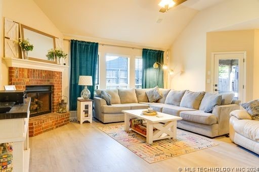 living room featuring hardwood / wood-style flooring, a healthy amount of sunlight, and vaulted ceiling