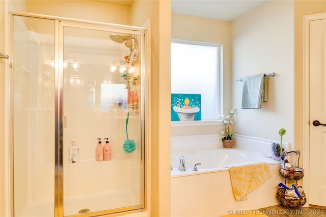 bathroom featuring plenty of natural light and independent shower and bath