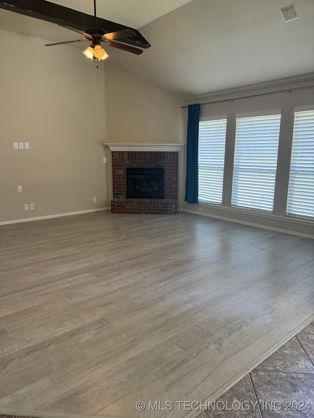 unfurnished living room featuring ceiling fan, light hardwood / wood-style flooring, a fireplace, and vaulted ceiling