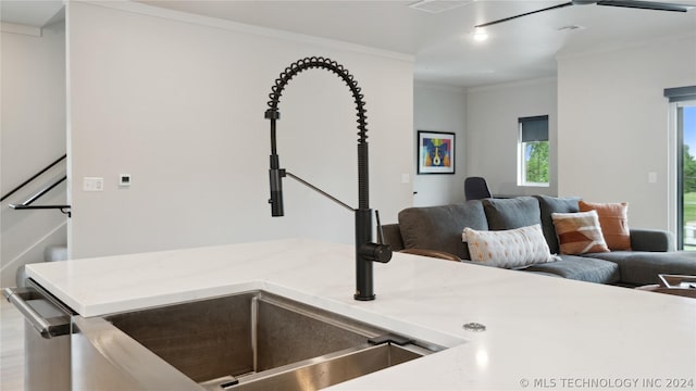 kitchen with sink, stainless steel dishwasher, and ornamental molding