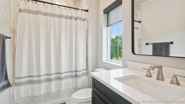 full bathroom featuring shower / bath combination with curtain, vanity, and toilet