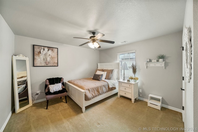 bedroom featuring ceiling fan, a textured ceiling, and light colored carpet