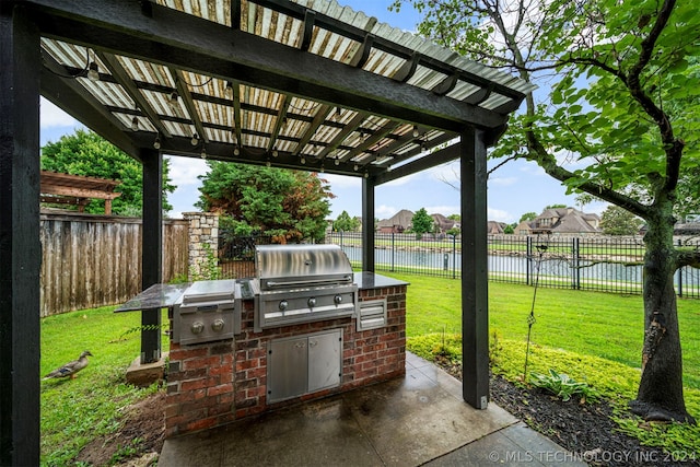 view of patio with grilling area, area for grilling, a water view, and a pergola