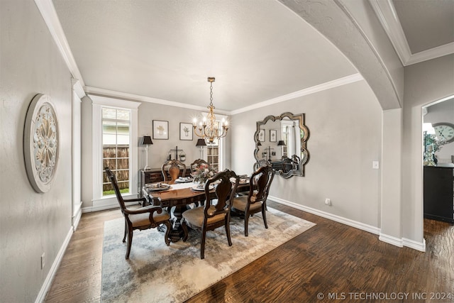 dining area featuring crown molding, dark hardwood / wood-style floors, and a notable chandelier