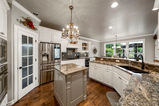 kitchen with white cabinetry, stainless steel appliances, stone counters, and pendant lighting