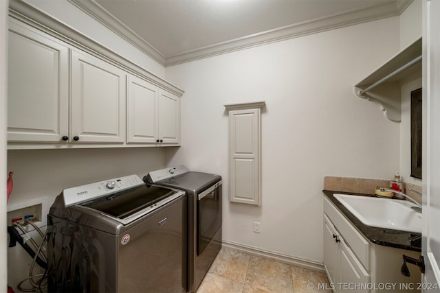 laundry area with cabinets, crown molding, sink, and washing machine and dryer