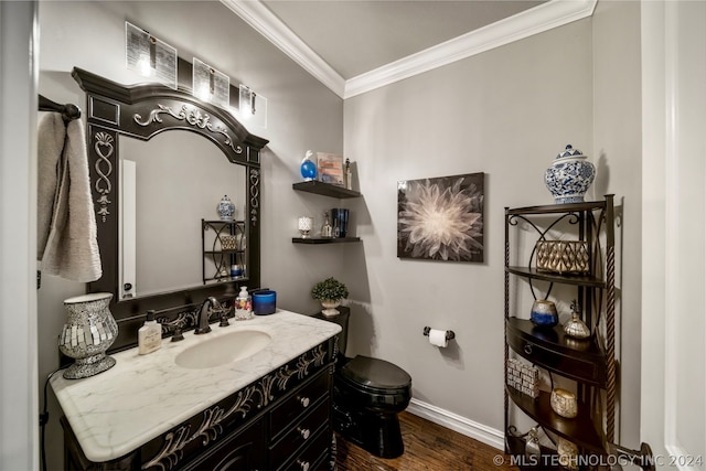 bathroom featuring vanity, hardwood / wood-style floors, ornamental molding, and toilet