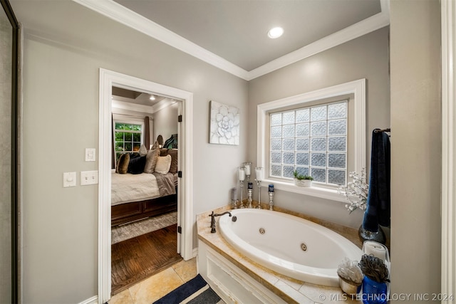 bathroom featuring ornamental molding, a healthy amount of sunlight, and tiled tub