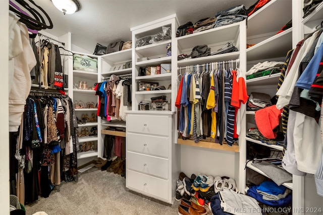 walk in closet featuring light colored carpet