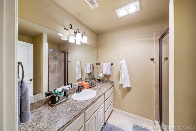 bathroom featuring vanity, tile patterned floors, and walk in shower