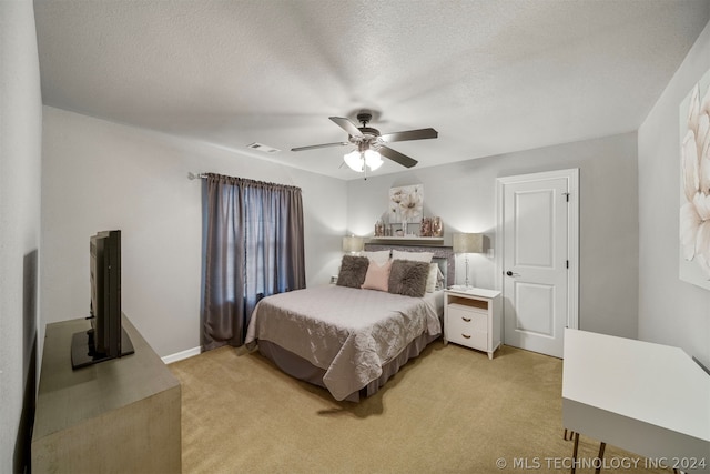 carpeted bedroom with a textured ceiling and ceiling fan