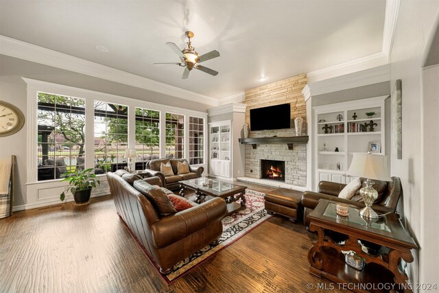 living room with ornamental molding, hardwood / wood-style floors, a fireplace, and ceiling fan