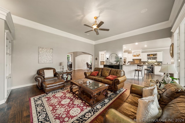 living room featuring ceiling fan, ornamental molding, and dark hardwood / wood-style floors