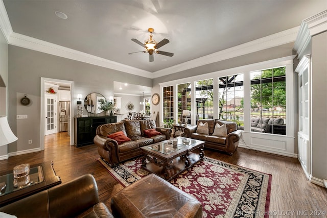 living room featuring ornamental molding, dark wood-type flooring, and ceiling fan