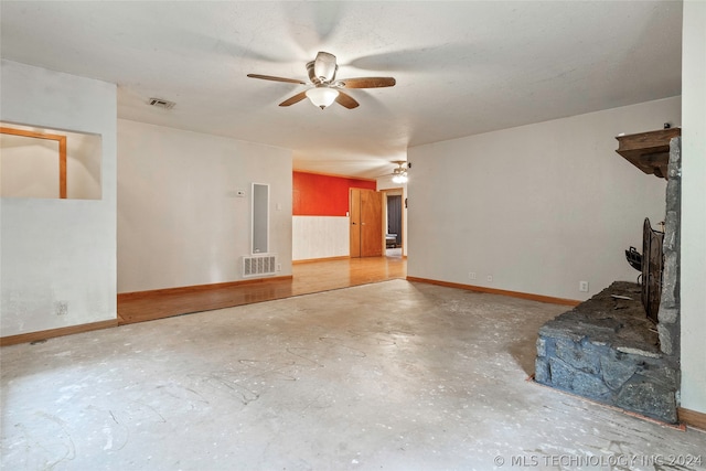 unfurnished living room with ceiling fan and concrete flooring