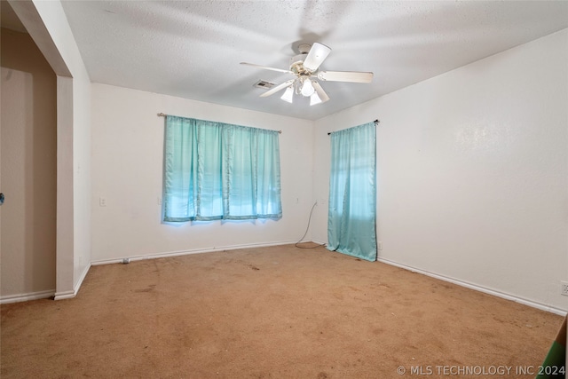 spare room with carpet, ceiling fan, and a textured ceiling