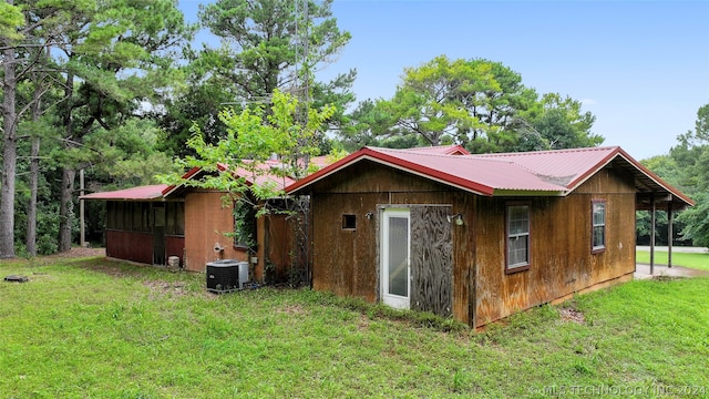 exterior space with central AC unit and a yard