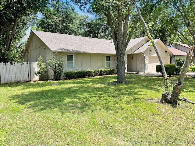 ranch-style home with a front lawn and a garage