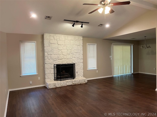 unfurnished living room with a fireplace, lofted ceiling with beams, ceiling fan with notable chandelier, and dark wood-type flooring