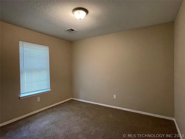 carpeted spare room featuring a textured ceiling