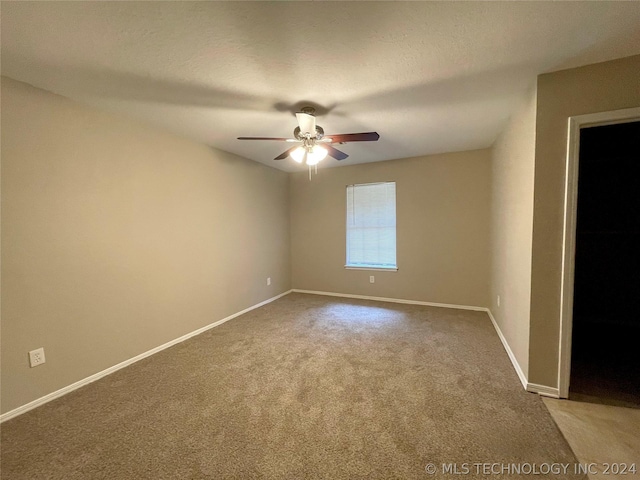 carpeted empty room featuring ceiling fan