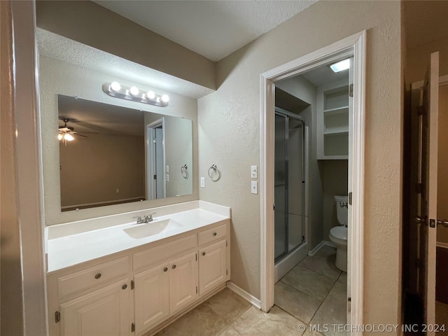 bathroom featuring ceiling fan, tile patterned floors, an enclosed shower, toilet, and vanity