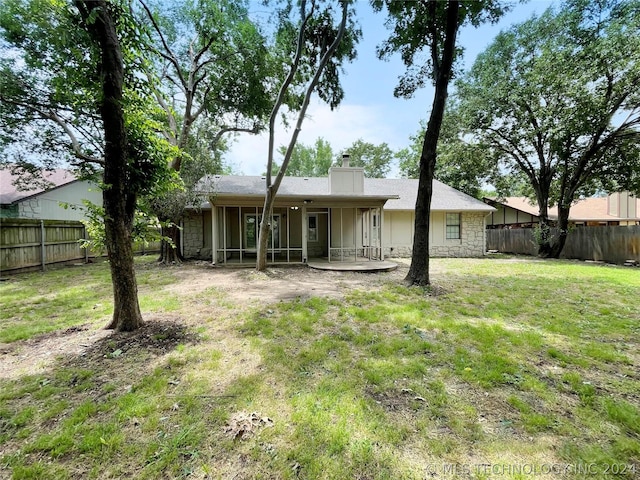 rear view of property featuring a lawn