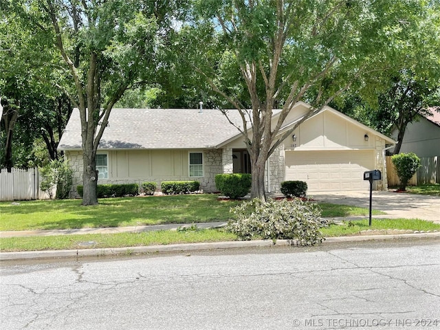 ranch-style house with a garage and a front lawn