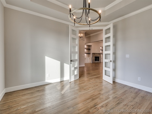 interior space featuring hardwood / wood-style floors, french doors, crown molding, and a notable chandelier