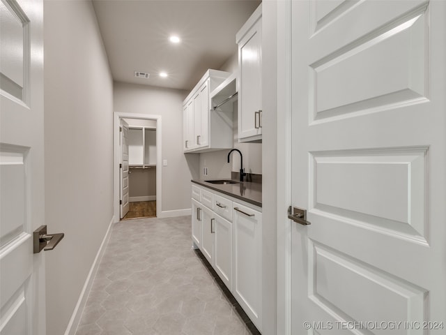 interior space featuring white cabinetry, sink, and light tile patterned flooring