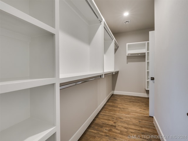 spacious closet with dark hardwood / wood-style flooring