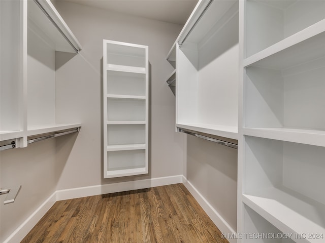 spacious closet featuring dark hardwood / wood-style floors