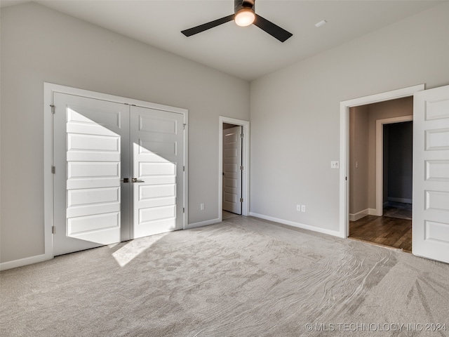 unfurnished bedroom with ceiling fan, a closet, and carpet