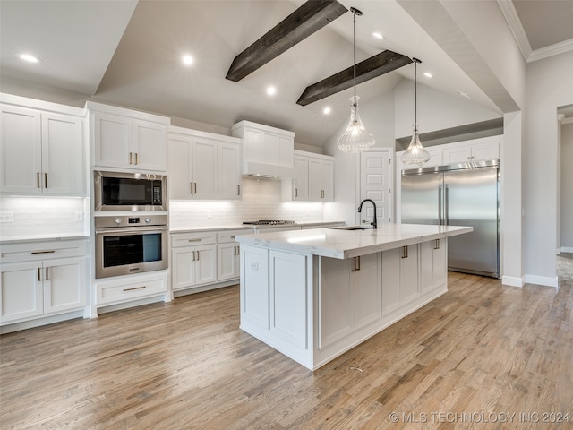 kitchen featuring white cabinets, light wood-type flooring, built in appliances, and tasteful backsplash