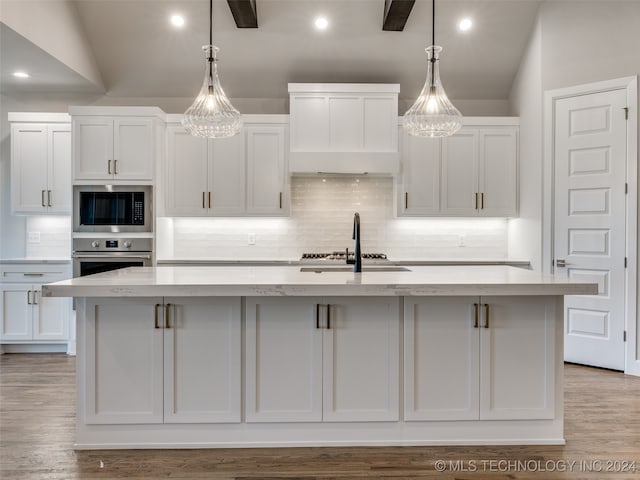 kitchen with a center island with sink and white cabinets