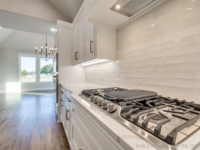 kitchen with white cabinetry, dark wood-type flooring, light stone counters, backsplash, and appliances with stainless steel finishes