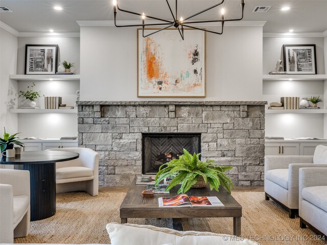 living room featuring a stone fireplace, built in shelves, ornamental molding, light wood-type flooring, and a notable chandelier