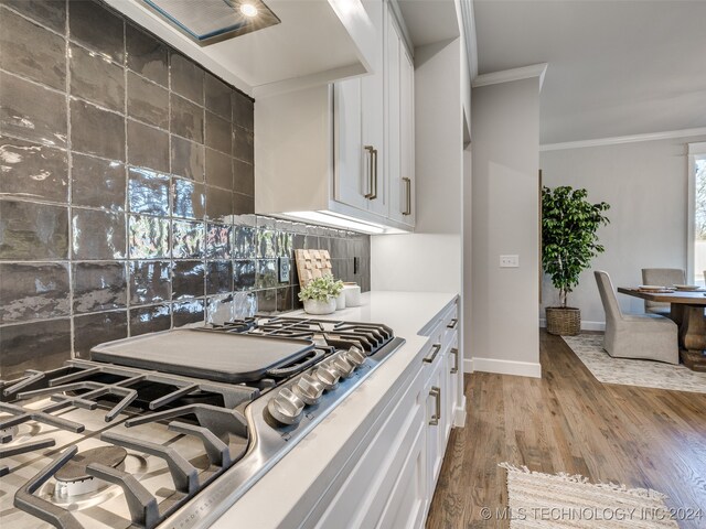 kitchen featuring white cabinetry, crown molding, stainless steel gas cooktop, and light hardwood / wood-style flooring