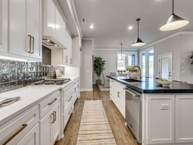 kitchen featuring a center island with sink, white cabinetry, and sink